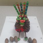 A character made of pinecones and colourful fabric
