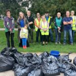 Volunteers standing behind bags of collected litter