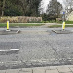 Road crossing with muddy path across grass
